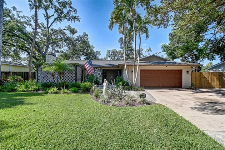 View of front of home featuring a garage and a front lawn