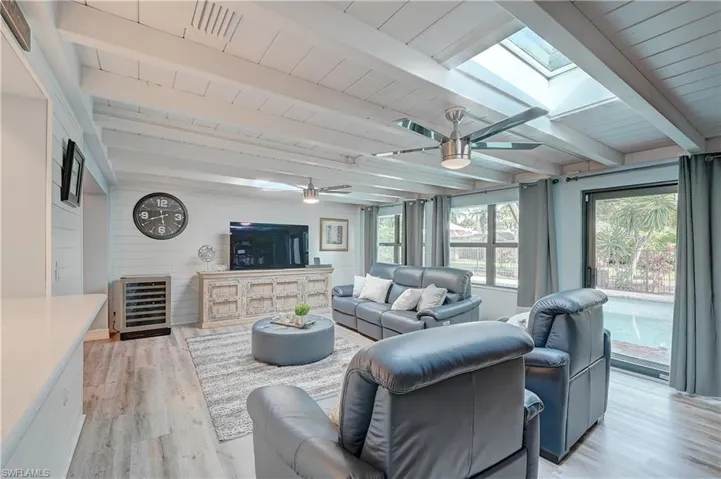 Family room featuring beamed ceiling and impact resistant skylights