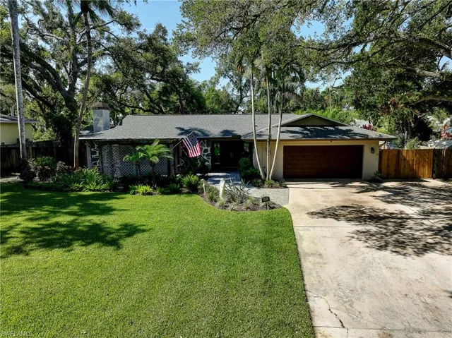 Ranch-style house with a garage and a front lawn