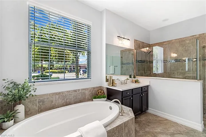 Bathroom with tile flooring, independent shower and soaking tub, and vanity