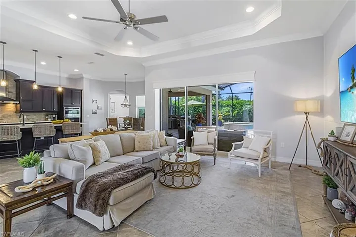 Living room featuring crown molding, tile flooring, and ceiling fan