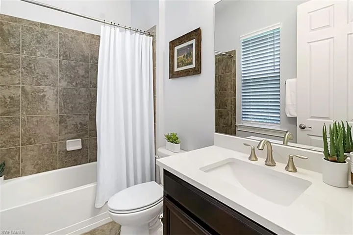 Full bathroom featuring shower / bath combo with shower curtain, oversized vanity, and toilet