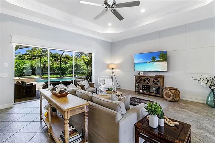 Tiled living room with crown molding, ceiling fan
