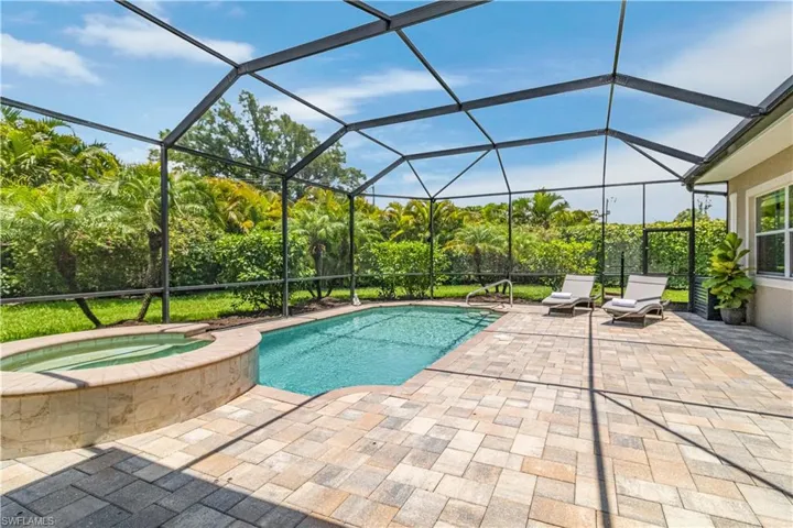 View of swimming pool with a lanai, an in ground spa