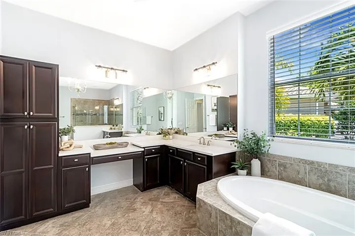 Bathroom with tile flooring, tiled bath, sink, and large vanity
