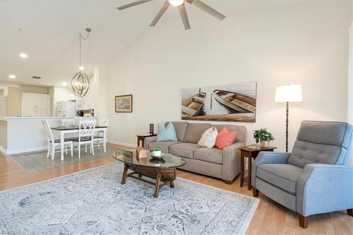 Living room with volume celings  72" modern ceiling fan, laminate light wood flooring