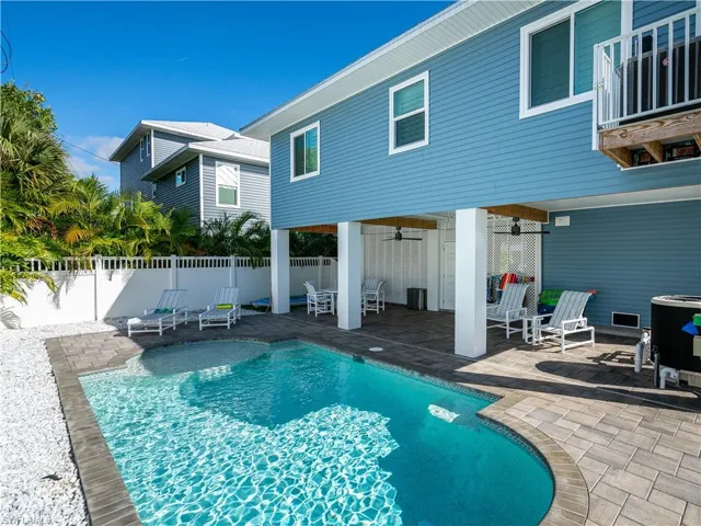 REAR PHOTO OF POOL ANDCOVERED LANAI AREA.