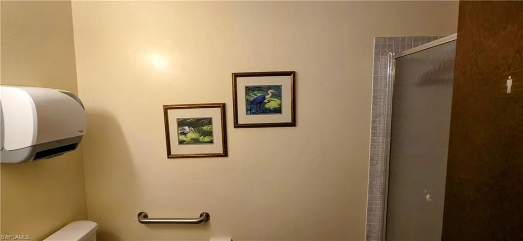 Full bath featuring a shower stall and toilet
