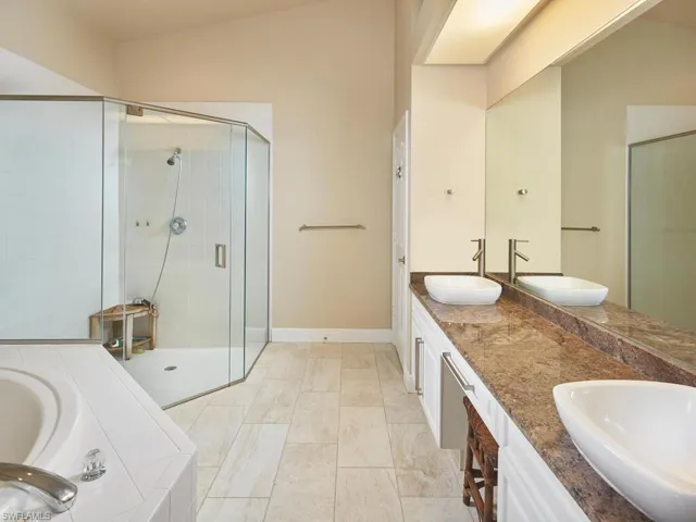 En suite primary bathroom with dual sinks and vanity.