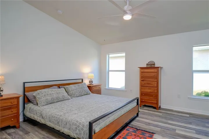 Bedroom featuring ceiling fan, baseboards, and wood finished floors