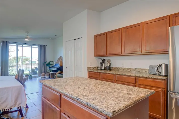 Kitchen with brown cabinets, freestanding refrigerator, open floor plan, and a center island