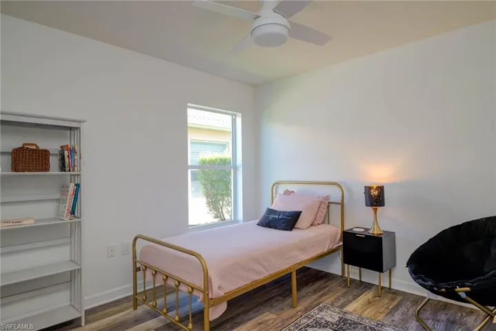 Bedroom featuring wood finished floors, a ceiling fan, and baseboards