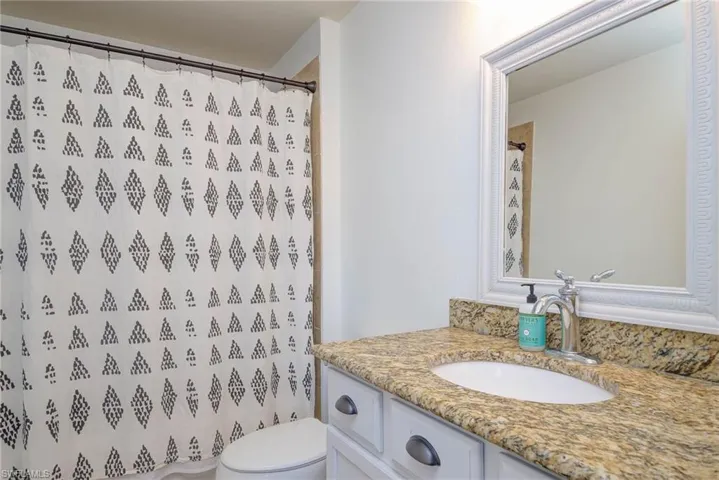 Full bath featuring toilet, vanity, and a shower with curtain