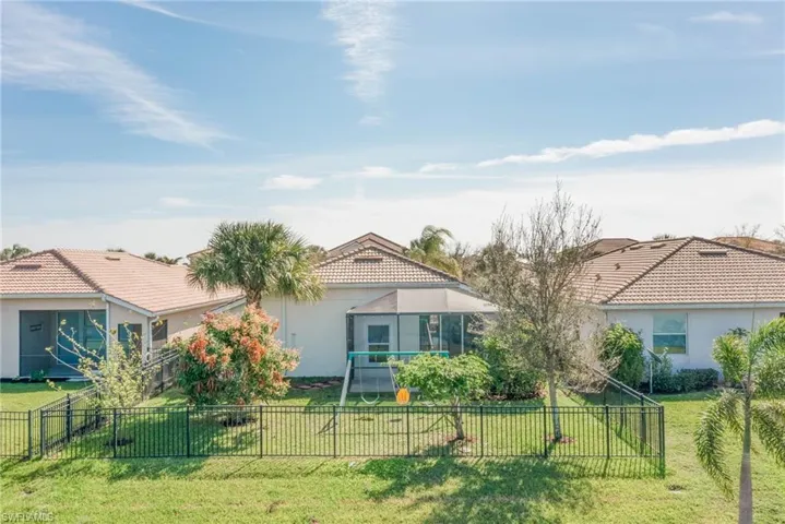 View of front of house with a front yard, a tiled roof, and stucco siding