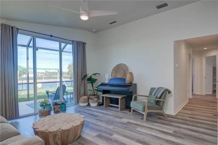 Sitting room with baseboards, visible vents, and light wood finished floors