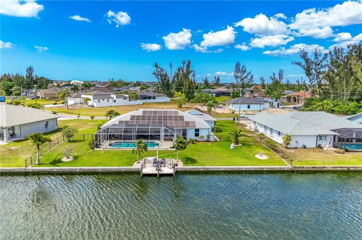 Aerial view of residential area with a large body of water, seawall and dock