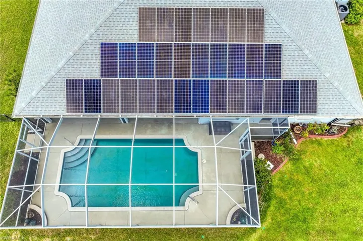 Aerial view of property and solar panels, surrounding area featuring a pool