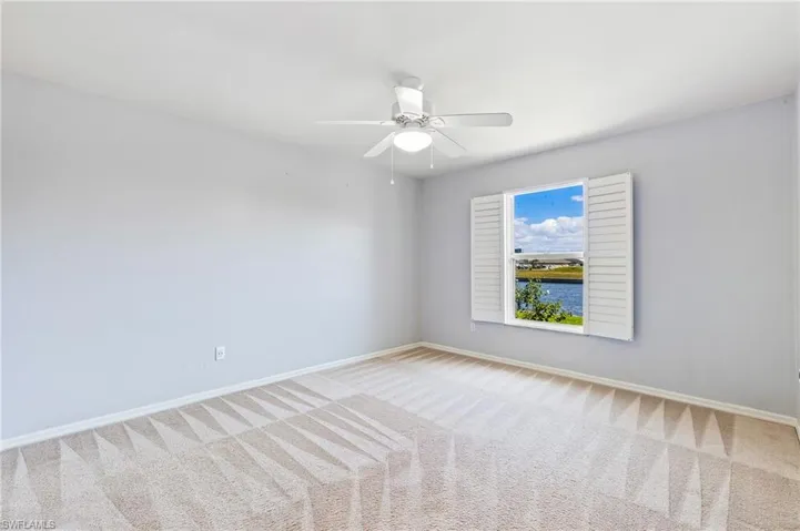 Bedroom with a ceiling fan and light carpet