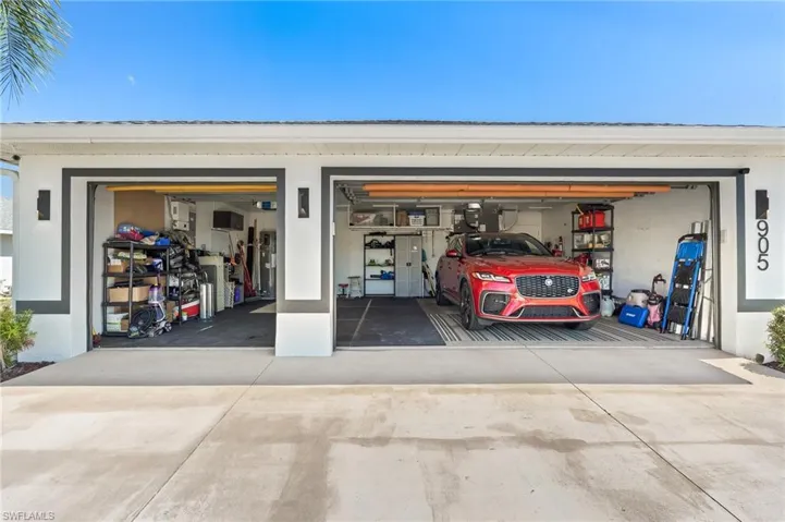 3 Car Garage featuring concrete driveway and water heater