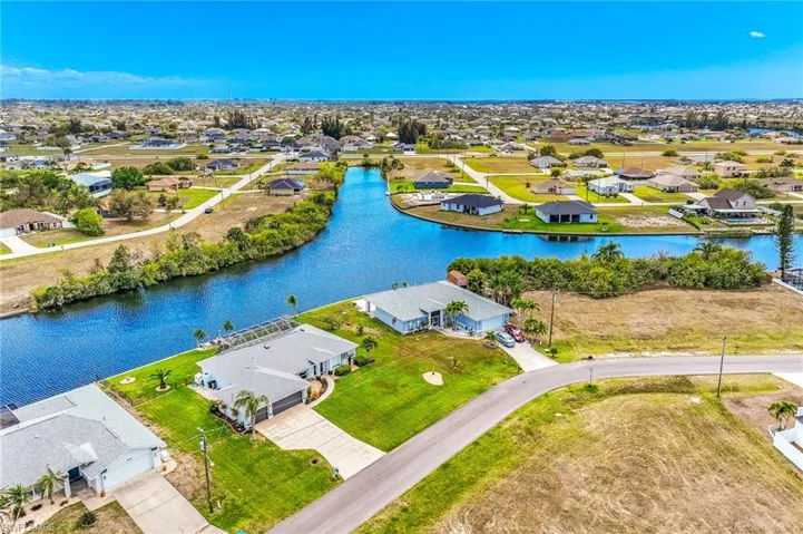 Aerial view of residential area featuring a nearby body of water