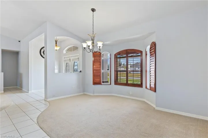 Dining room featuring suspended lighting, light carpet, and light tile patterned floors