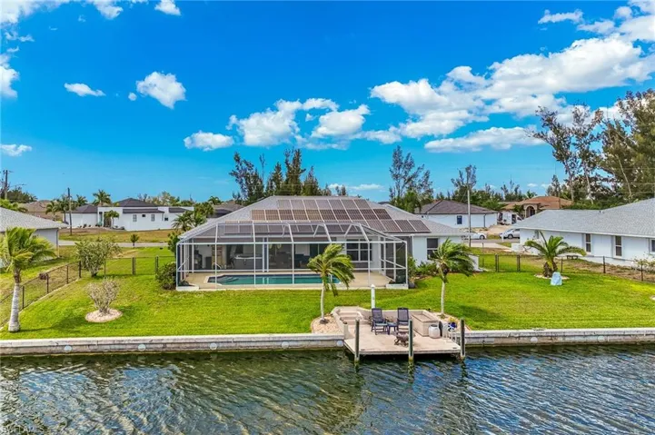 Rear view of property with a fenced backyard, a water view, a screen and a lanai