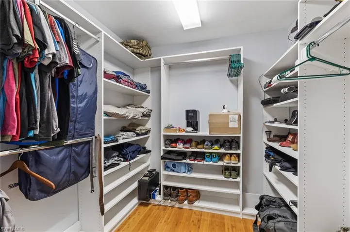 Walk in closet with light wood-type flooring