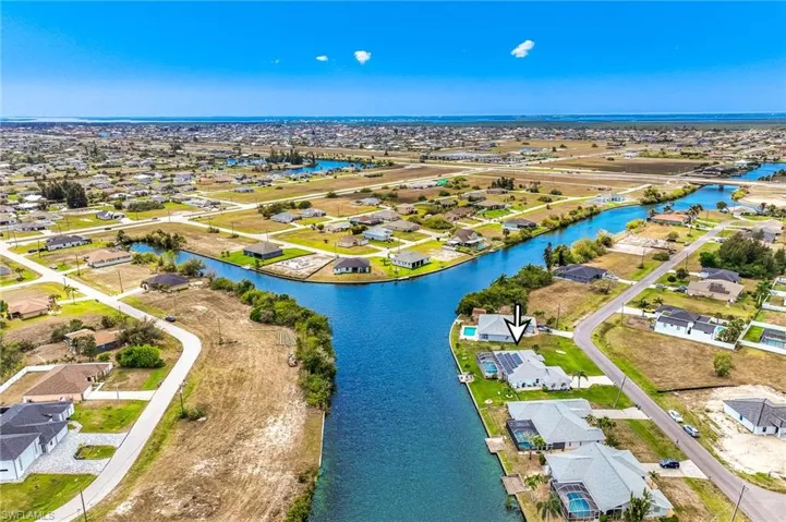 Aerial view of property and surrounding area with nearby suburban area and a nearby body of water
