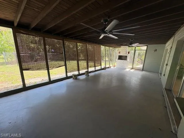 Unfurnished sunroom featuring a ceiling fan