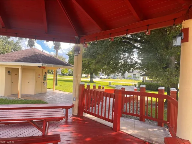 Expansive covered outdoor deck with red wood flooring and matching railings