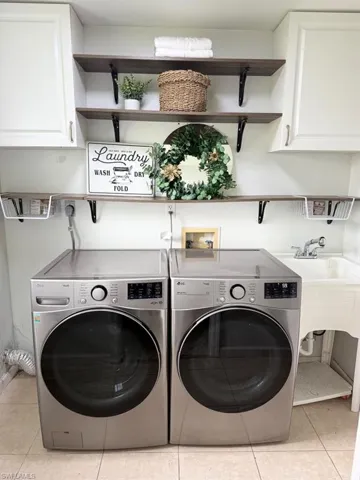 Built-in upper cabinetry, wood-finish shelving with black brackets, and a utility sink with chrome faucet