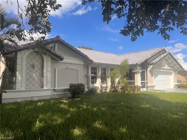 Single-story residence featuring a tile roof, stucco exterior, decorative arched window, and an integrated garage