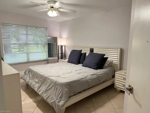 Room with tile flooring, a large window, and a ceiling fan