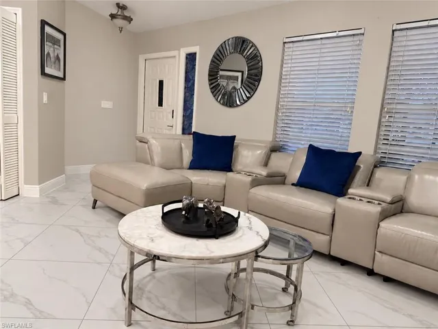 White tile flooring, multiple windows with blinds, recessed lighting, and a paneled entry door