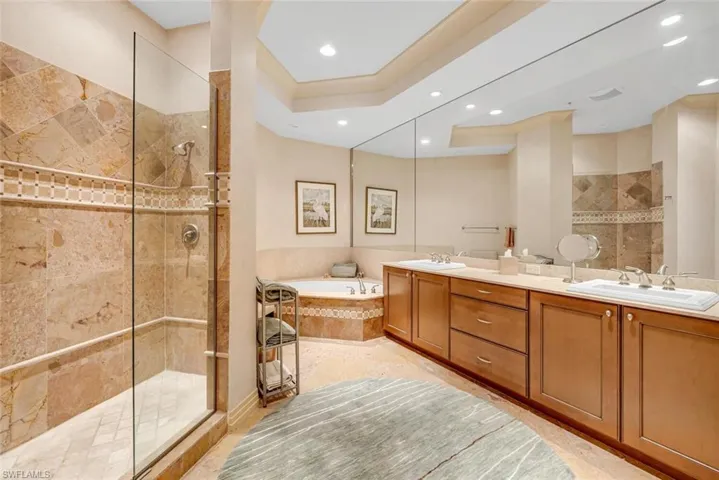 Bathroom featuring vanity and independent shower and bath