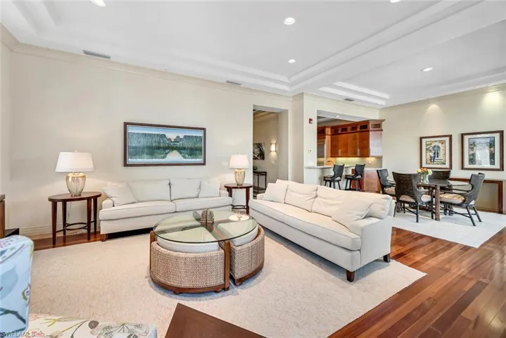 Living room with a tray ceiling and hardwood / wood-style flooring