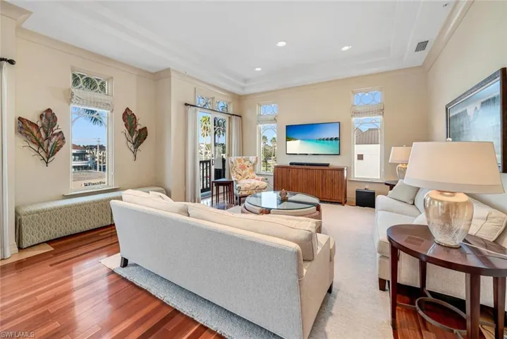 Living room with hardwood / wood-style flooring and ornamental molding