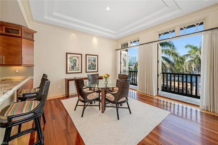 Dining area featuring a tray ceiling, built in desk, and dark hardwood / wood-style floors