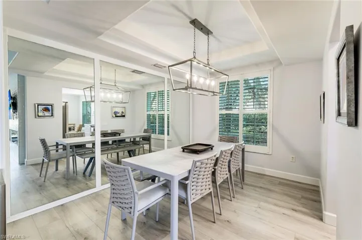 Dining Area with tray ceiling detail, updated chandelier, and plantation shutter framed window! Located just off of the Family Room and kitchen!