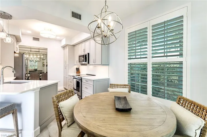 Breakfast nook just off of your beautiful updated kitchen with a lovely window framed by plantation shutters and updated chandelier!