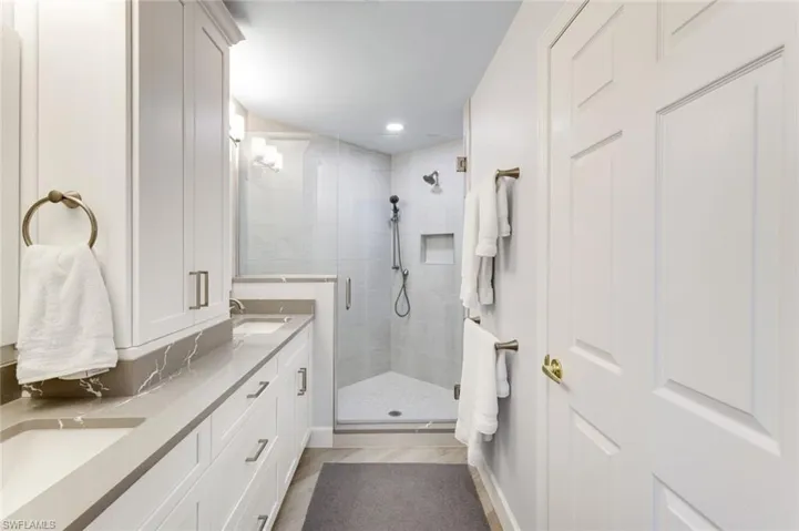 Primary bathroom with double sinks, crisp shaker style cabinetry, modern pulls and a frameless glass walk-in shower!