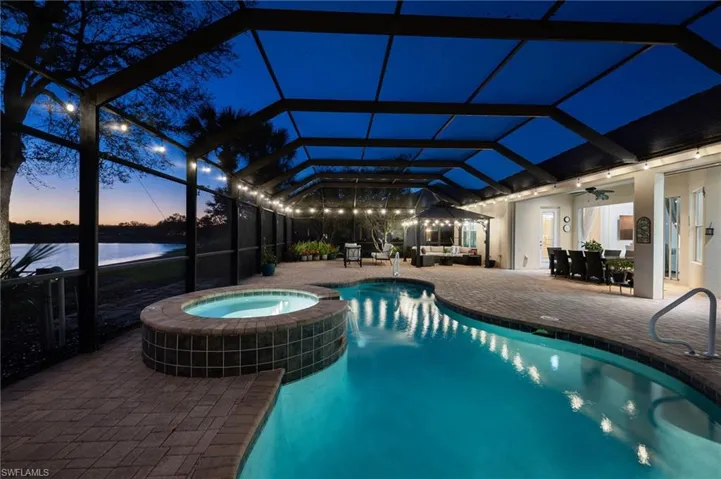 Night shot of pool lights and lanai
