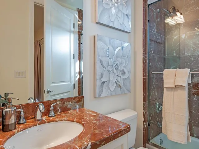 Bathroom featuring vanity and combined bath / shower with glass door