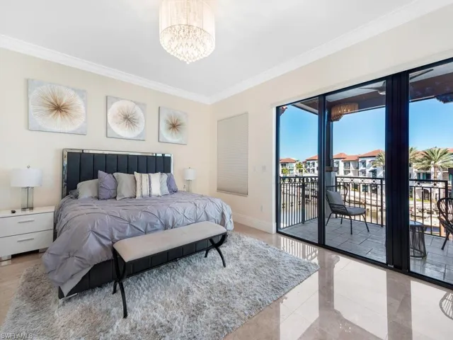 Bedroom with ornamental molding, access to exterior, and a chandelier