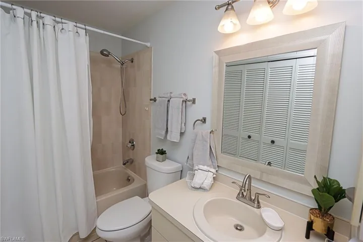 Full bathroom featuring shower / bath combination with curtain, vanity, and toilet