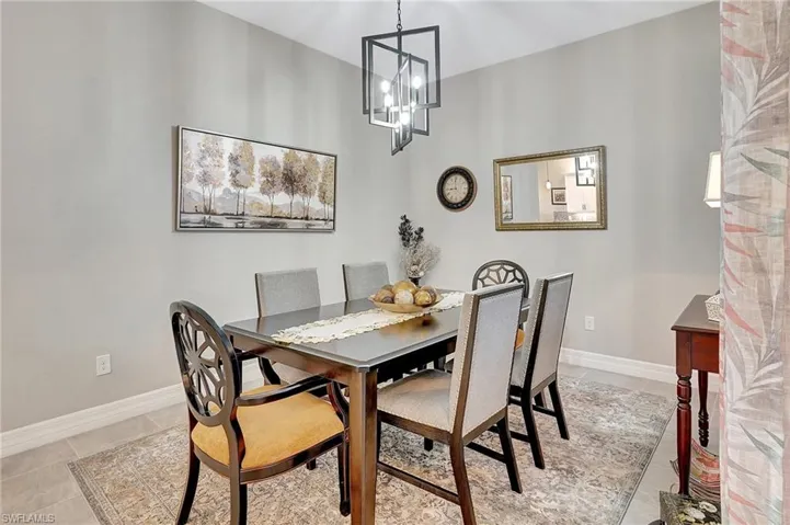 Dining area featuring baseboards, a chandelier, and light tile patterned floors
