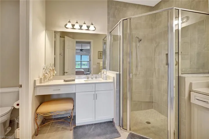 Full bathroom featuring vanity, ensuite bath, toilet, and a shower stall