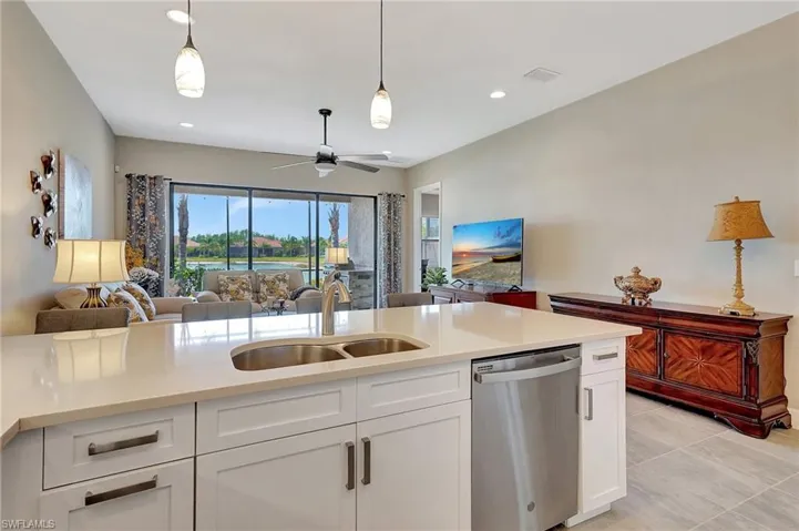 Kitchen with open floor plan, stainless steel dishwasher, a sink, visible vents, and a ceiling fan