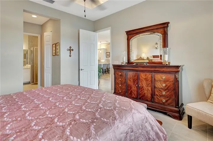 Bedroom featuring connected bathroom, visible vents, and light tile patterned floors