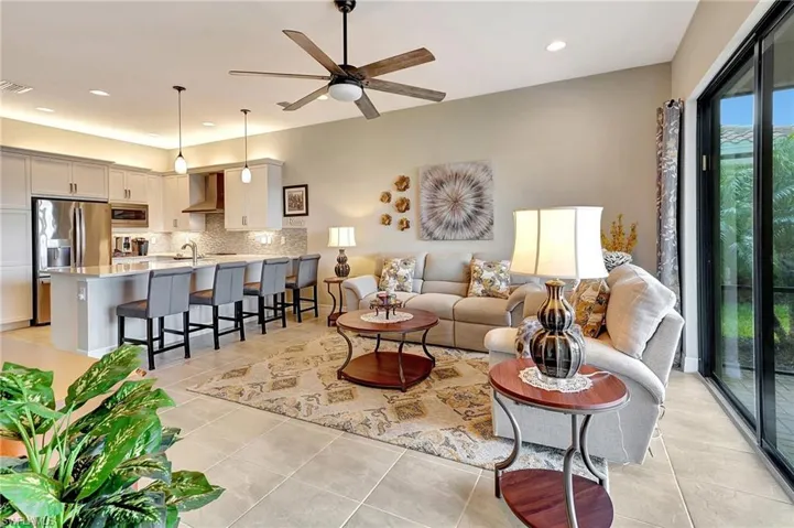 Living room featuring a ceiling fan, visible vents, light tile patterned floors, and recessed lighting